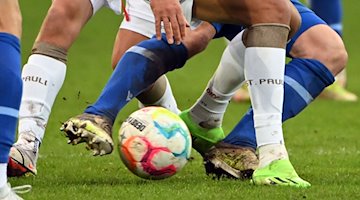 Soccer players of two opposing teams fight for the ball / Photo: Uli Deck/dpa/Symbolbild