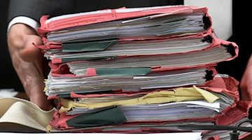 Trial files are placed on a table at the beginning of a hearing in a courtroom / Photo: Holger Hollemann/dpa/Symbolic image